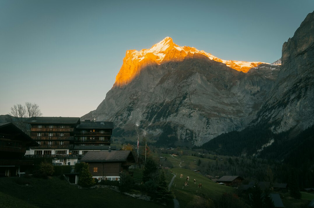 Elegant Swiss chalet villa exterior at dusk with warm lighting